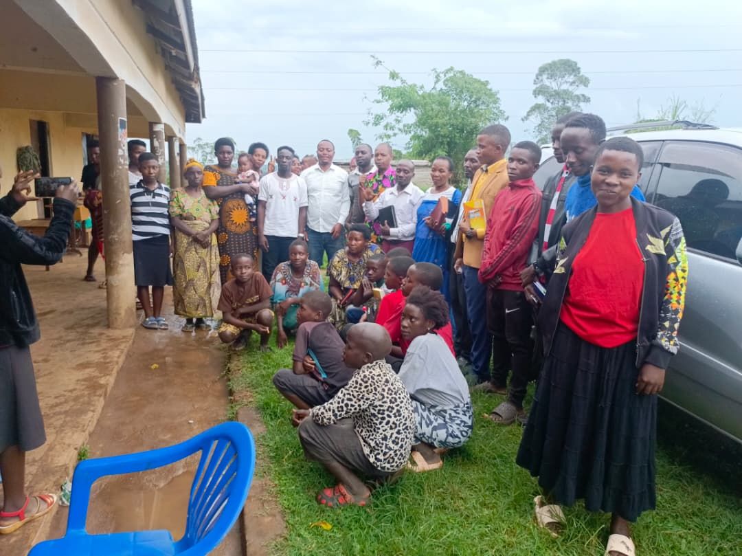 TVIA team members with community representatives outdoors in rural Uganda