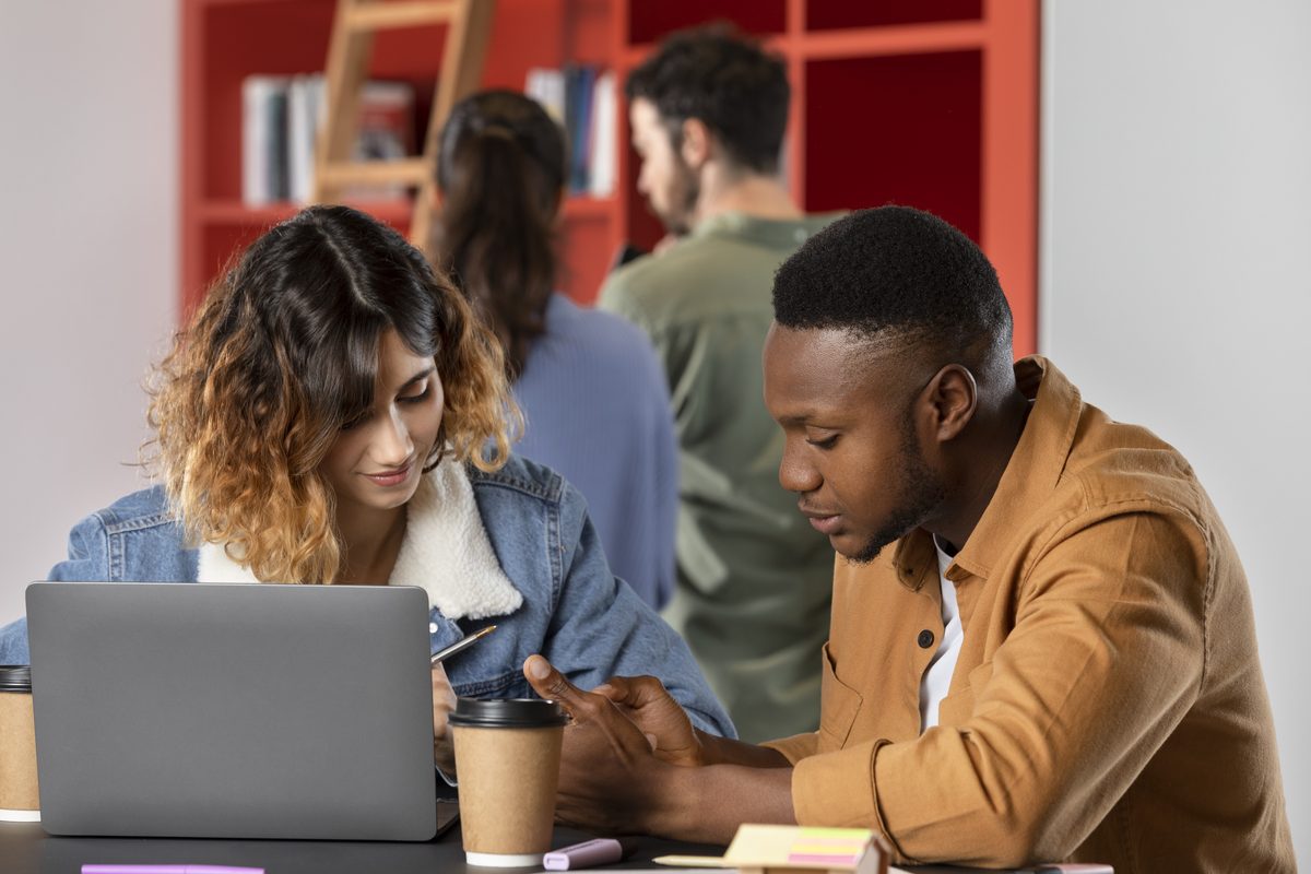 Two students reviewing study notes together on a laptop